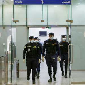 رجال أمن يرتدون أقنعة واقية من كورونا في مطار الكويت