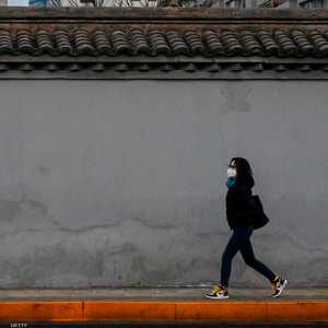 بالكمامة.. تمشي وحيدة في أحد شوارع بكين