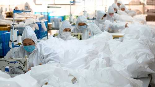 عمال بالكمامات داخل مصنع صيني