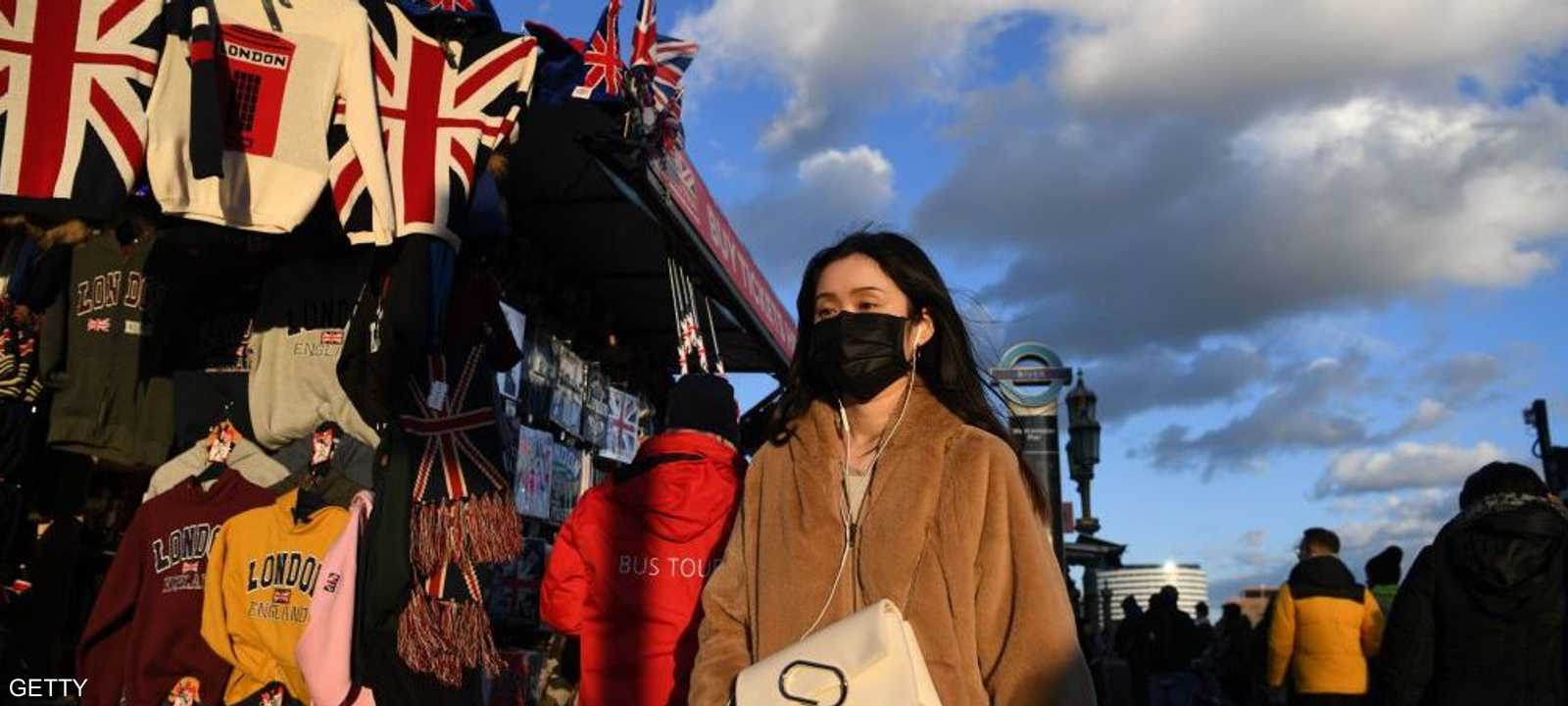 فتاة ترتدي كمامة صحية في أحد شوارع لندن