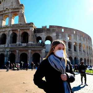 سيدة ترتدي كمامة واقية خارج المدرج الروماني في روما
