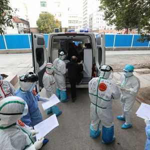 طاقم طبي يساعد مصابا بفيروس كورونا في الصين