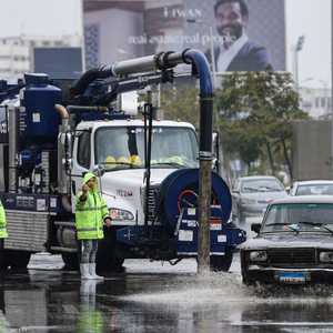 عمال مصريون يقومون بتصريف المياه في أحد شوارع القاهرة