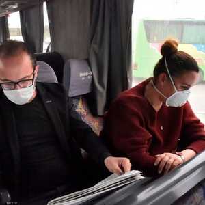 امرأة ورجل يرتديان كمامات واقية في حافلة بالجزائر