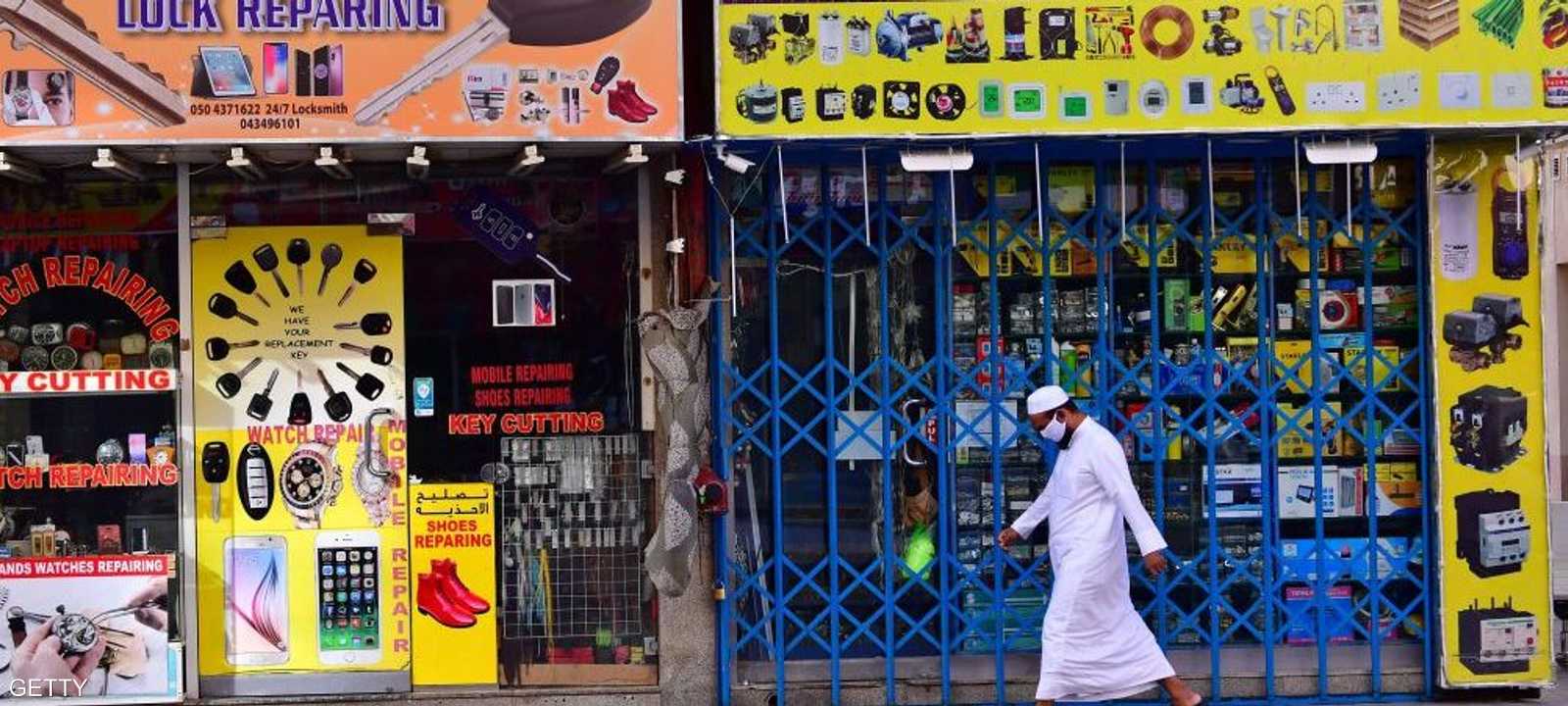 رجل يرتدي كمامة للوقاية من فيروس كورونا يسير بأحد شوارع دبي