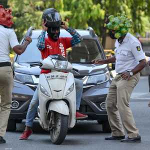 عنصران من الشرطة الهندية يرتديان خوذة على هيئة كورونا