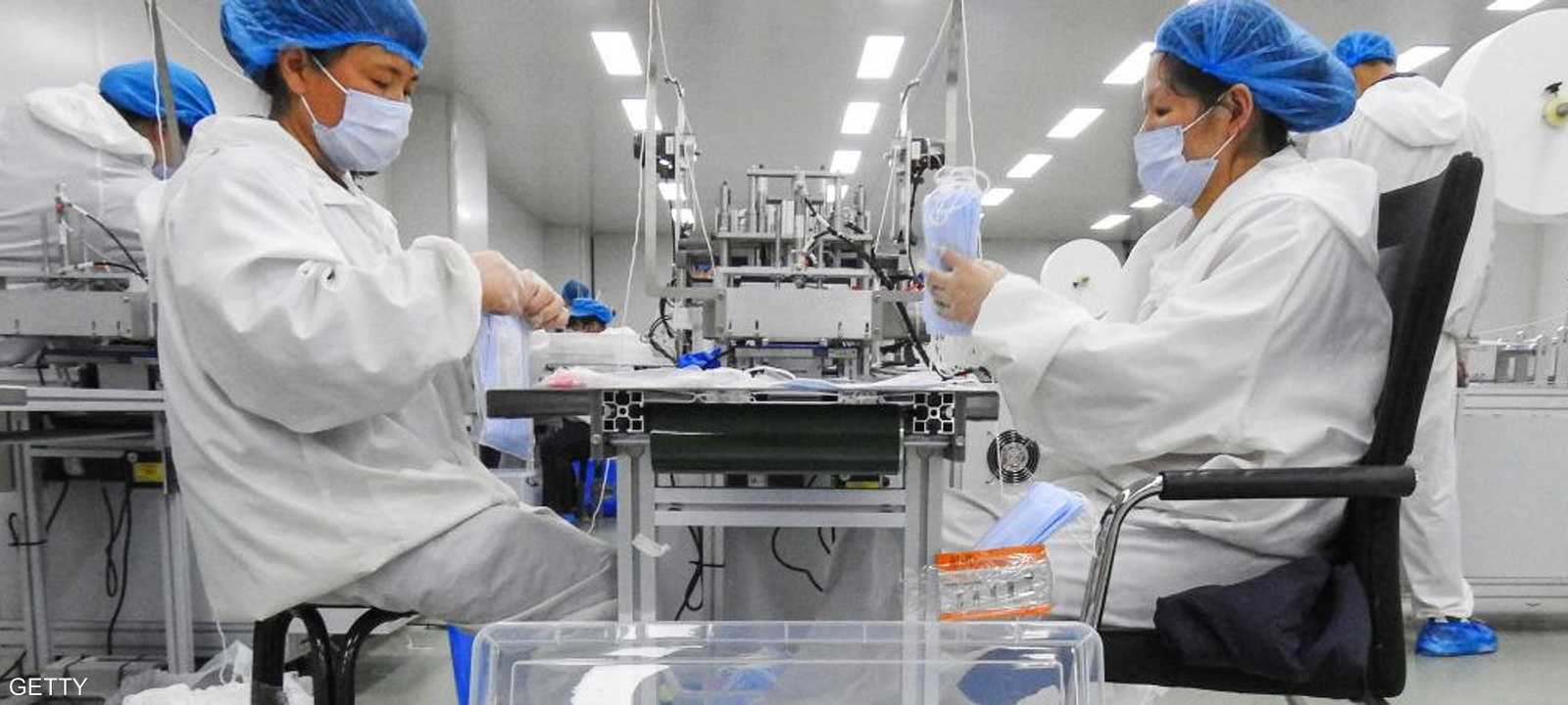 عاملتان في مصنع صيني لإنتاج الكمامات