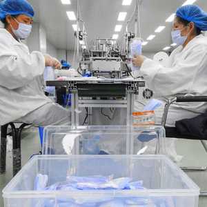 عاملتان في مصنع صيني لإنتاج الكمامات