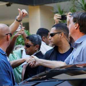 بولسونارو يصافح أحد أنصاره في برازيليا