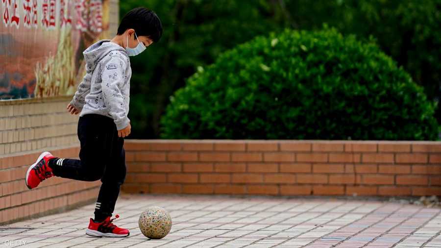 طفل صيني يداعب الكرة في بكين.