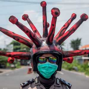 شرطي يرتدي قبعة على شكل فيروس كورونا في إندونيسيا.