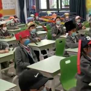 الطلاب ارتدوا قبعات بزوائد جانبية لتطبيق التباعد