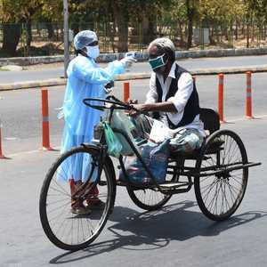 عاملة في مجال الصحة تفحص مواطنا في أحد شوارع الهند