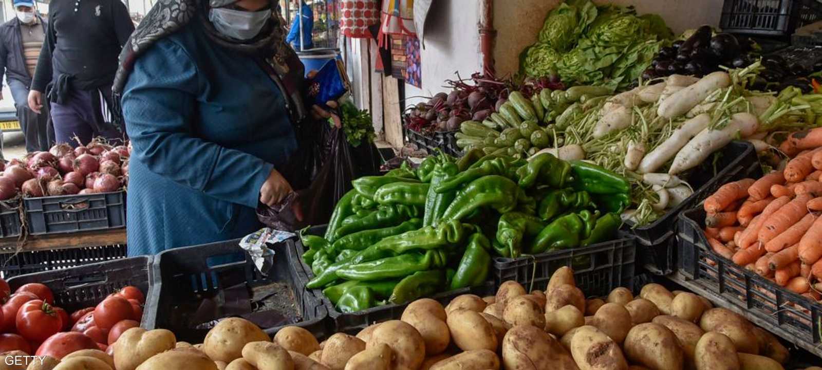 تشتري الخضراوات من أحد أسواق العاصمة الجزائر