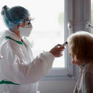 ممرضة تقيس درجة حرارة مريضة بوحدة صحية في فرنسا.