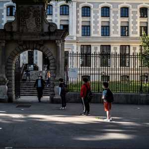 طلبة يرتدون الكمامات ينتظرون دورهم لدخول مدرستهم بليون