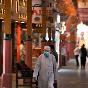رجل يرتدي كمامة أثناء سيره بأحد أسواق مدينة دبي الإماراتية