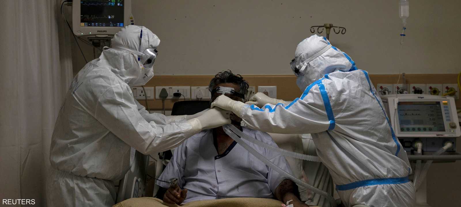 اثنان من الأطقم الطبية يتابعان حالة مريض بكوفيد-19 بنيودلهي.