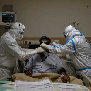 اثنان من الأطقم الطبية يتابعان حالة مريض بكوفيد-19 بنيودلهي.