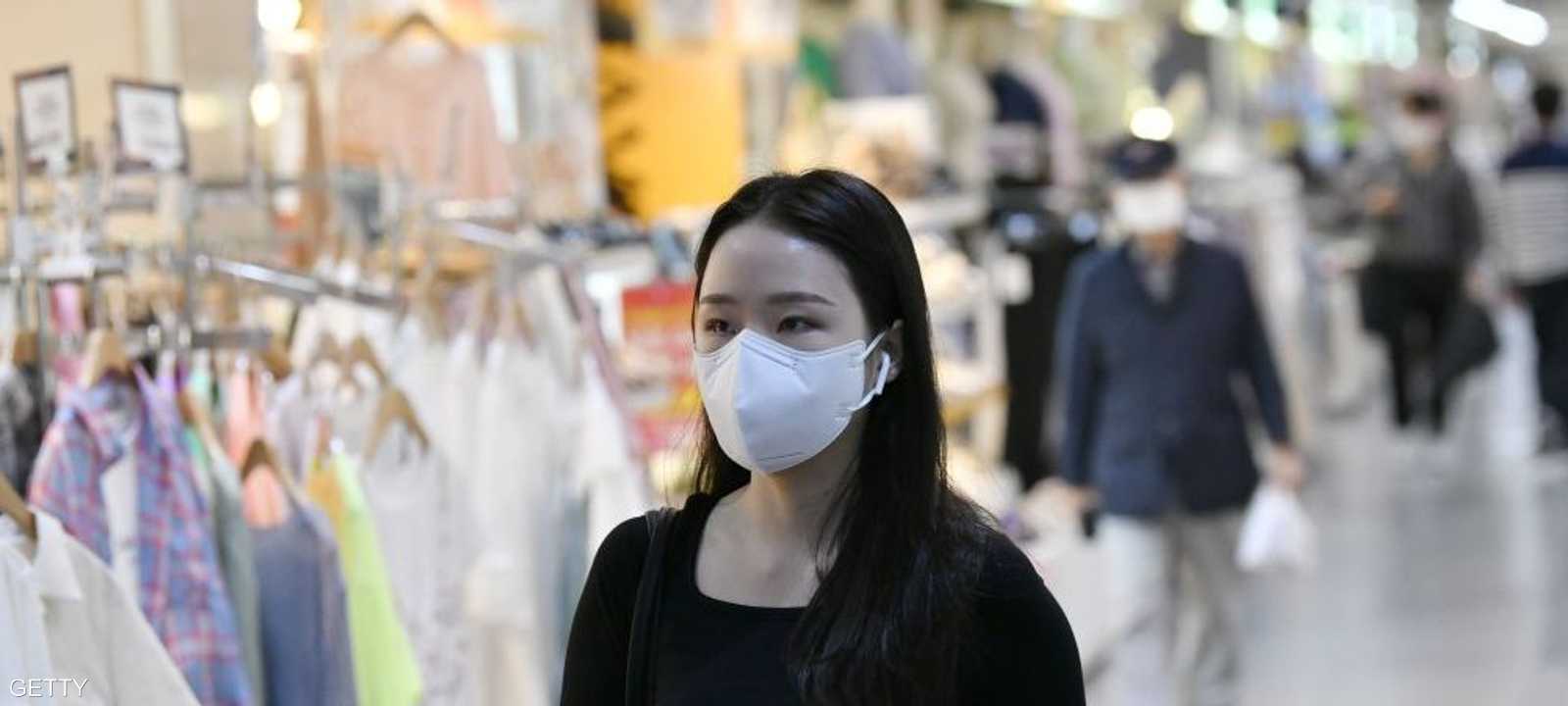 فتاة ترتدي كمامة في أحد مراكز التسوف بالعاصمة سول