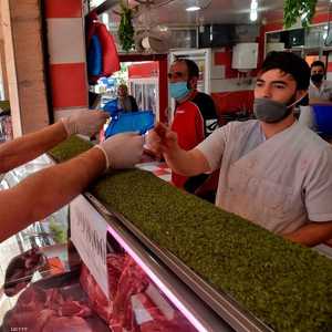 متطوعون يوزعون كمامات في محل جزارة بالجزائر العاصمة.