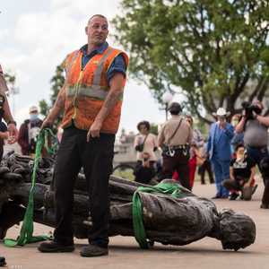 شرطيون يقفون بجوار تمثال كريستوفر كولومبس الذي أسقطه محتجون.