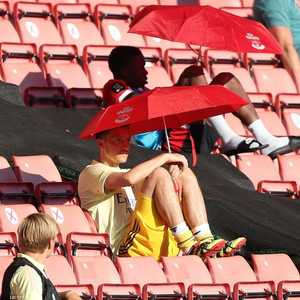 أوزيل محتميا بمظلة على مقاعد البدلاء في الدوري