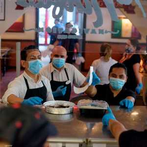 يرتدون الكمامات بأحد المطاعم