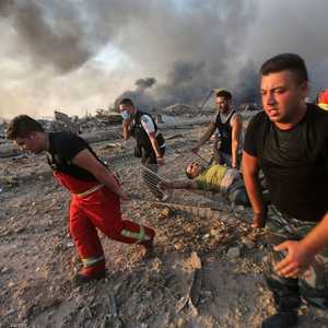 عملية نقل أحد الجرحى من موقع انفجار بمرفأ بيروت