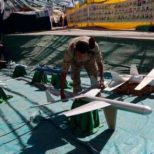 أحد أفراد ميليشيات الحوثي يعاين طائرة بدون طيار.