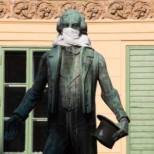 تمثال يوهان نيستروي في فيينا يرتدي قناعا خلال تفشي كورونا