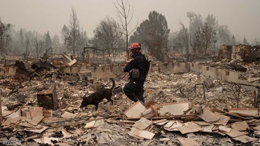 يواصل رجال الإنقاذ أعمالهم وسط الركام الذي خلفه حرائق الغابات.