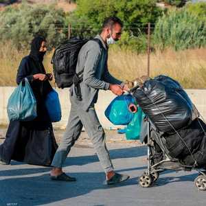 خرج سكان مخيم موريا في جزيرة ليسبوس حاملين أمتعتهم