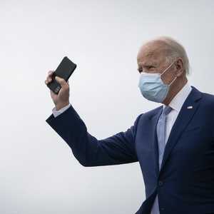 بايدن يلوح بهاتفه الذكي خلال إحدى جولاته الانتخابية للرئاسة.