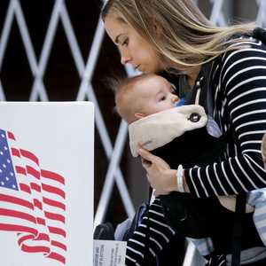 سيدة أميركية تدلي بصوتها رفقة صغيرها.