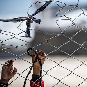 طفل يعبث بالسياج المحيط بمخيم الهول في الحسكة