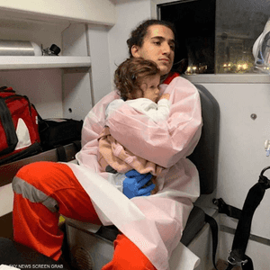 المسعف زياد بكار يحتضن الطفلة جودي بسيارة الإسعاف