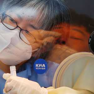 انعكاس لصورة شخص يخضع لفحص كورونا بأحد أكشاك فحص الفيروس