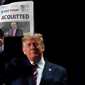 الرئيس الأميركي دونالد ترامب يحمل جريدة تحمل عنوان "مبرأ"