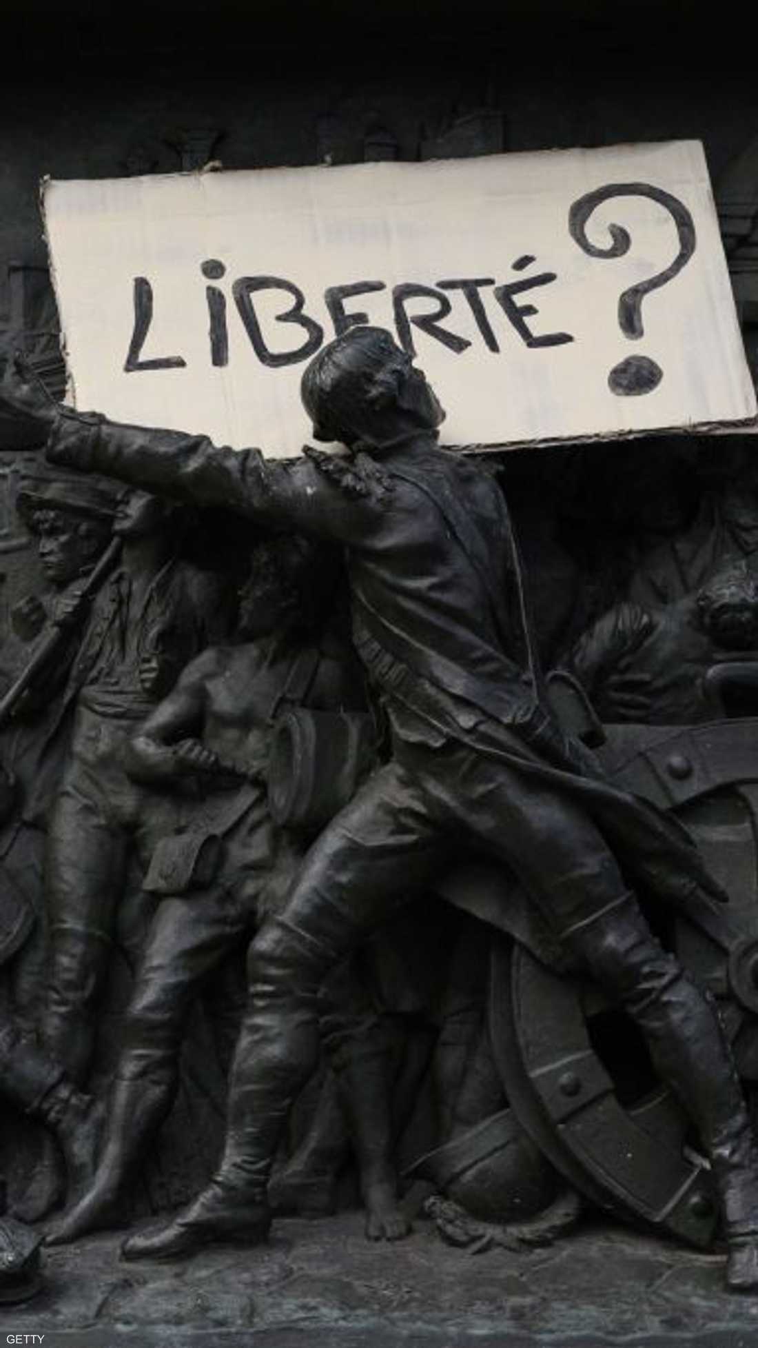 لافتة عن "الحرية" فوق تمثال أثناء الاحتجاج على القانون المثير للجدل