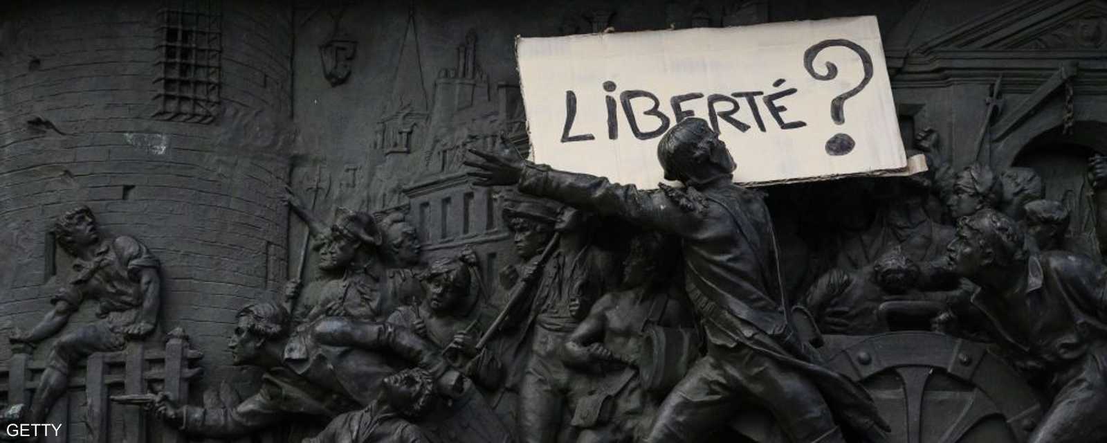 لافتة عن "الحرية" فوق تمثال أثناء الاحتجاج على القانون المثير للجدل