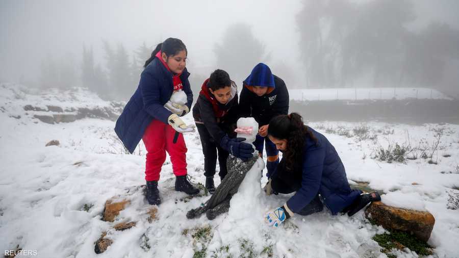 أطفال فلسطينيون يبنون رجل ثلج بعد تساقط الثلوج على رام الله