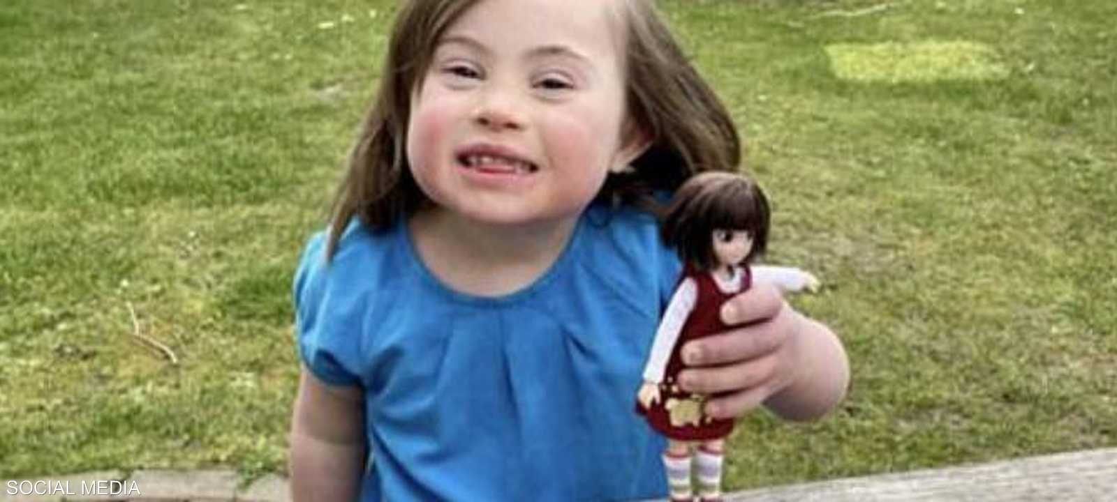 الطفلة روزي تمسك بالدمية