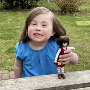 الطفلة روزي تمسك بالدمية