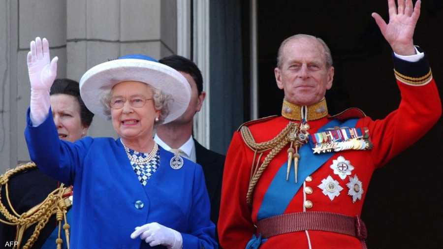ملكة بريطانيا والأمير فيليب يلوحان من شرفة قصر باكنغهام