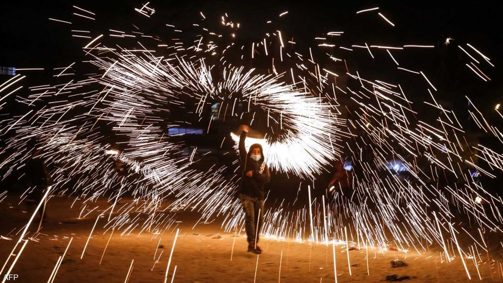 فتى فلسطيني يحتفي بقدوم رمضان بشعلة نارية