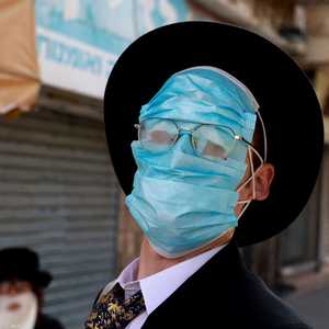 أحد اليهود الأرثوذكس يرتدي عدة كمامات في عيد الفور اليهودي