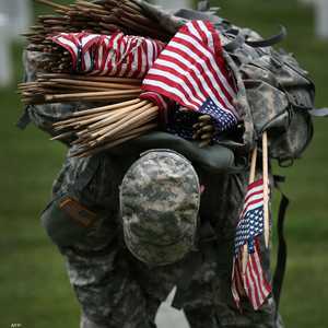 جندي من المارينز يعتل على كاهله  الأعلام الأميركية