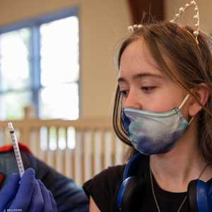 إحدى الفتيات تتلقى لقاح كورونا