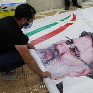 عامل يطبع ملصقا دعائيا للمرشح الرئاسي إبراهيم رئيسي